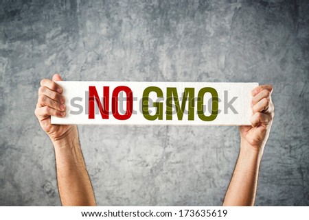 No GMO. Man holding banner with Anti GMO message. Royalty-Free Stock Photo #173635619
