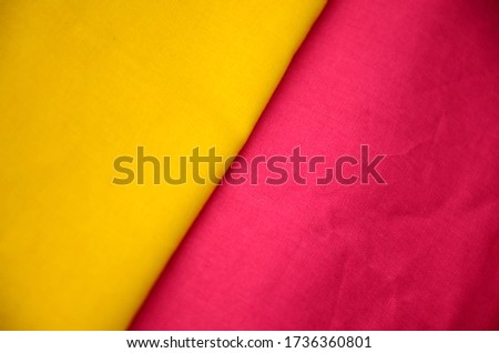 The fabric is diagonally yellow and pink. Horizontal photo, background