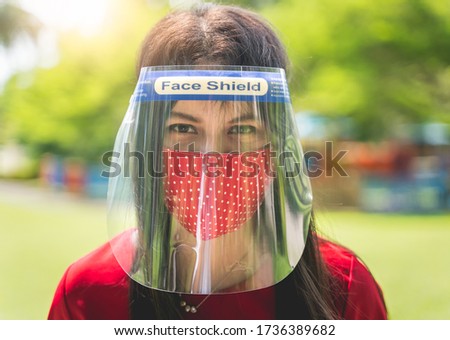 Women wearing Face shield, Asian women use face protection and cloth masks to prevent infection and reduce risk during the outbreak and use a New Normal lifestyle with blur public park background Royalty-Free Stock Photo #1736389682