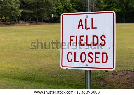 All Fields Closed sign by an empty soccer field, coronavirus shutdown of sports, horizontal aspect Royalty-Free Stock Photo #1736393003