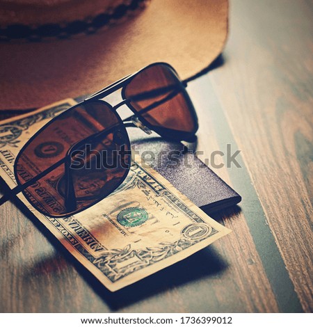 Items for summer vacation: a camera, passport,smartphone, money, hat, sunglasses. Wooden background, top view with Copy space. Beautiful summer concept for travel.