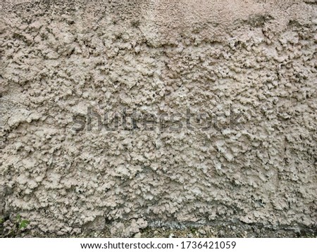 Wall of gray concrete with high pimples.