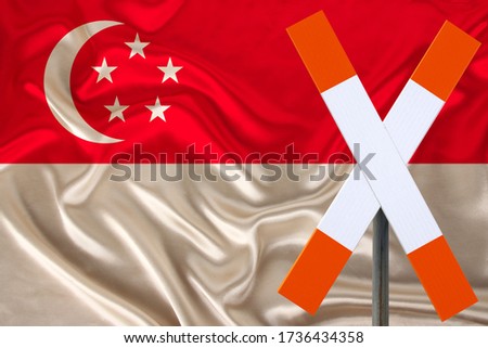 sign, stop, attention on the background of the silk national flag of Singapore, the concept of border and customs control, violation of the state border, tourism restrictions