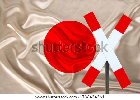 customs sign, stop, attention on the background of the silk national flag of japan, the concept of border and customs control, violation of the state border, tourism restrictions