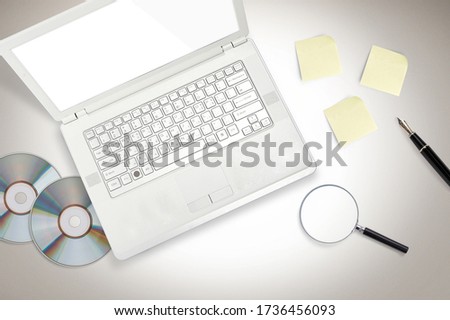 LAPTOP with CD-ROM paper pen on the desk  Royalty-Free Stock Photo #1736456093