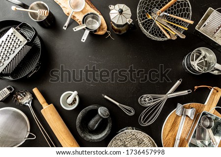 Kitchen utensils (cooking tools) on black chalkboard background. Kitchenware collection captured from above (top view, flat lay). Layout with free copy (text) space. Royalty-Free Stock Photo #1736457998