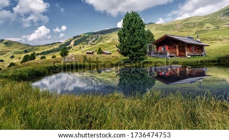 Fabulous Mountain scenery in summer. Photo of wooden house on the shore of the lake, under sunlit on highland. Amazing nature landscape. Picture of wild area. concept of Travel and holiday on nature