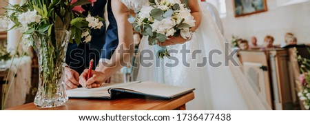 Beautiful bride in the church signs a marriage certificate. Wedding concept.