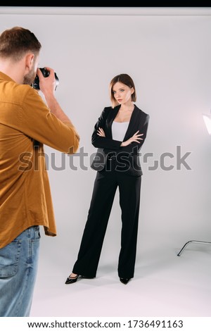 Photographer working with beautiful stylish model in photo studio
