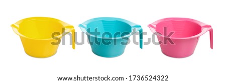 plastic bowl for manicure or hair coloring. measuring cup isolated on white background