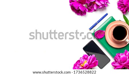 Beautiful flowers peonies, cup of coffee, green notebook, phone, pen on a white background top view with copy space. Female desktop, planning, morning coffee