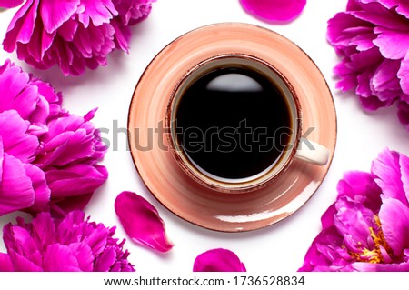Cup of black coffee and beautiful flowers peonies on white background top view. Morning coffee, female desktop. Spring or summer coffee concept, pink cup of drink