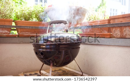 Smokey small bbq grill outside on balcony in spring