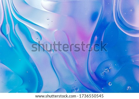 Close-up of the movement of oil droplets on the water surface. Colorful abstract macro background of oil drops on the water surface Royalty-Free Stock Photo #1736550545