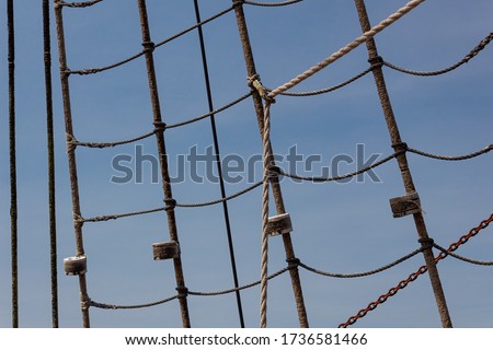 Background wrapped and sealed shroud from an old tallship, rope and chain against a beautiful blue sky, horizontal aspect