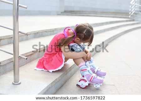 little girl sat down to relax after rollerblading