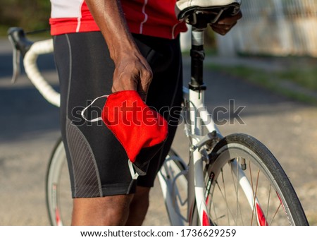 The Masked Cyclist during covid-19. Preparation to go on the streets is vital. Royalty-Free Stock Photo #1736629259
