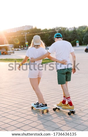 in one sunny day fashionable couple of hipster longboarding in the park