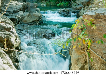 Beautiful green water waterfalls surrounded by rocks in a bright morning. Hike. Nature. Walking. Discover. Texture. Flow.