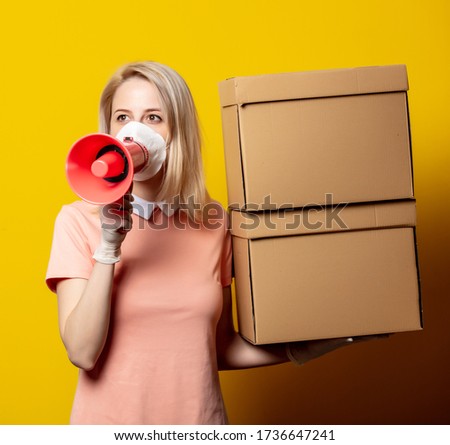 Blonde girl in face mask with delivery boxes and megaphone on yellow background.