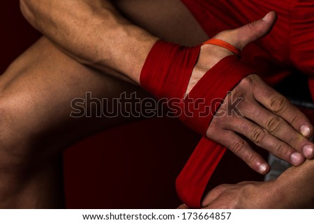 Fighter Putting Straps On His Hands - Muscled Boxer Wearing Red Strap On Wrist