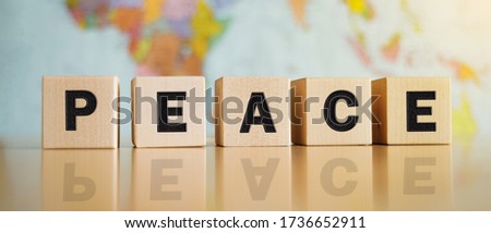 The word peace written on wooden cubes isolated on a political map background