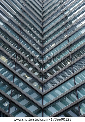 a full frame modern office architecture abstract with geometric angular reflected shapes and lines in blue glass windows