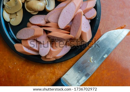 Fresh Sausage and mushroom cut in slices on plate.