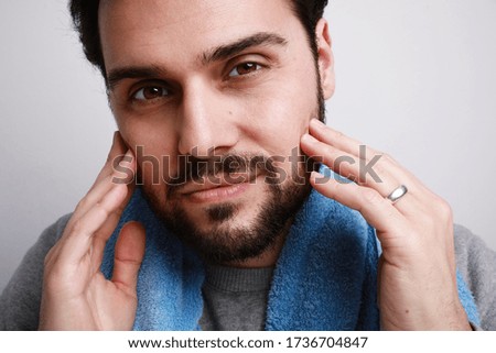 Bearded man looking straight, smiling isolated on grey background. Concept of cheerful, happy, attractive male model.