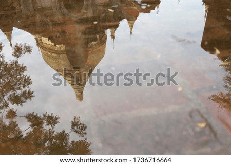 Reflection of the golden stupa (Shwezigon Temple) in puddle, Bagan