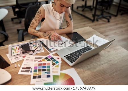 Young and beautiful creative female designer making a sketch while sitting at her workplace in the office. Web design. Creative occupation. Business and career. UX UI design