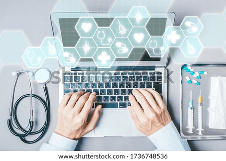 Male doctor examining with a laptop