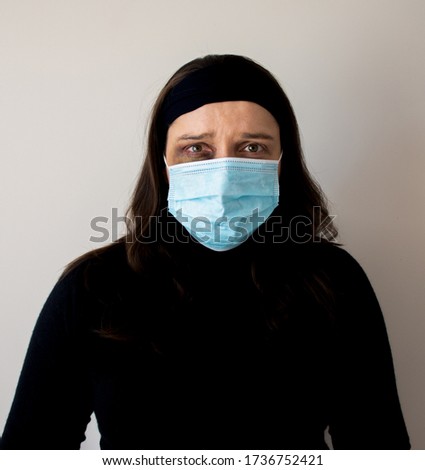 A woman is trying to hide traces of domestic violence by wearing a medical mask. epidemic and domestic violence  concept. The concept of rising domestic violence during quarantine isolation  Royalty-Free Stock Photo #1736752421