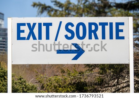 a bilingual English French exit sign pointing to the right