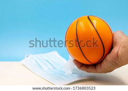 Hand is cleaning basketball on blue background