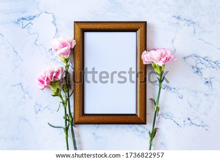 Carnation flower on blank picture frame on marble background, Valentine's Day, Mother's Day or Birthday background