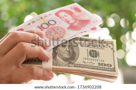 Hand holding banknote money china and us dollar. Concept  The struggle for power between various China and America.