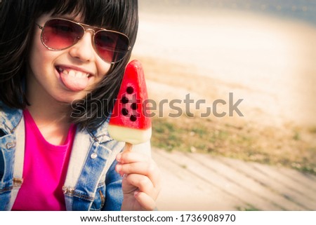 little girl eating a watermelon ice cream