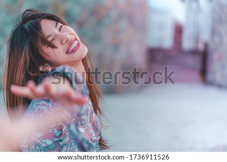 Happy Asian woman is holding hand and pulling her boyfriend on a beach, for Happy Summer Vacation dating concept.