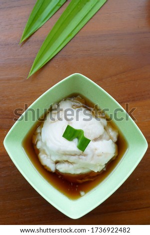 Bubur or jenang sum sum, indonesian sweet coconut rice porridge. Bubur sum sum is an Indonesian dessert made by cooking rice flour in coconut milk and served with palm sugar syrup. Selective Focus