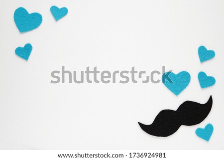Happy fathers day background with copy space decorated with handmade felt fabric mustache and blue hearts, dad symbol.
