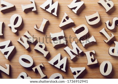 Wooden letters on a wooden background. Abstract background top view