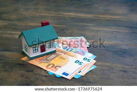 A modern house stands on euro banknotes 50, 20, 10. The concept of wealth, purchase, sale, rental of real estate, mortgage. Place for text