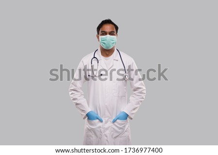 Male Doctor Wearing Medical Mask and Gloves Standing Isolated. Indian Man Doctor Medical Workwear. Medical Concept Royalty-Free Stock Photo #1736977400