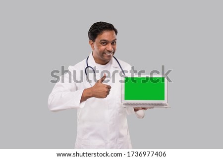 Doctor Showing Thump Up with Laptop Green Screen Isolated. Male Indian Doctor with Laptop in Hands.