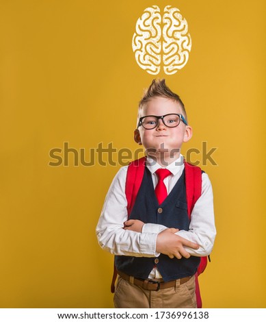 Funny kid in school uniform and bag with picture of brain above. 