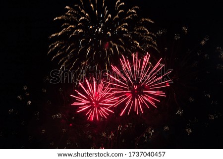 Beautiful Holiday background with red fireworks. Fireworks explode in night sky. Template to design Greeting card for holidays: Christmas, New year, anniversary, independence day, Birthday.