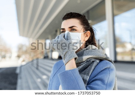 health, safety and pandemic concept - young woman wearing protective medical mask in city