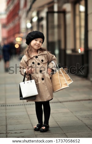 Little girl on shopping in the city.
Image with selective focus, noise effects and toning. Focus on the girl.