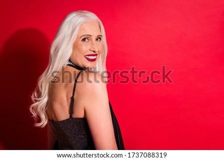 Profile photo of attractive aged grey haired lady luxury look evening makeup posing camera toothy smile photographing wear shine glossy fashion dress isolated red color background